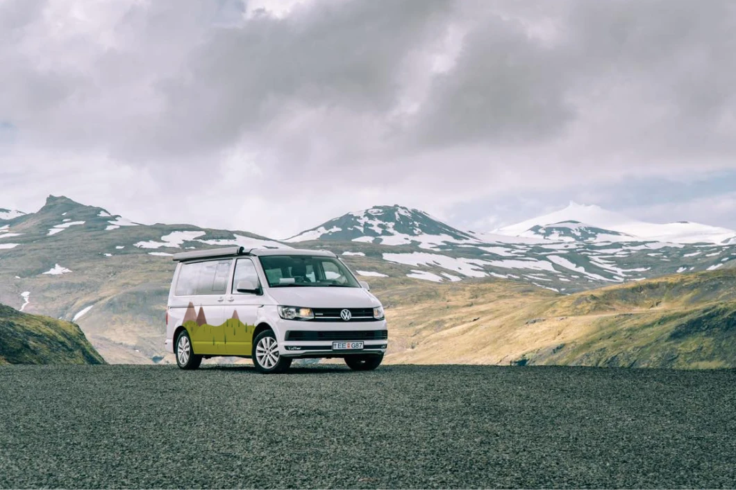 Furgone camperizzato Volkswagen Transporter 4x4 parcheggiato di fronte a picchi innevati in Islanda