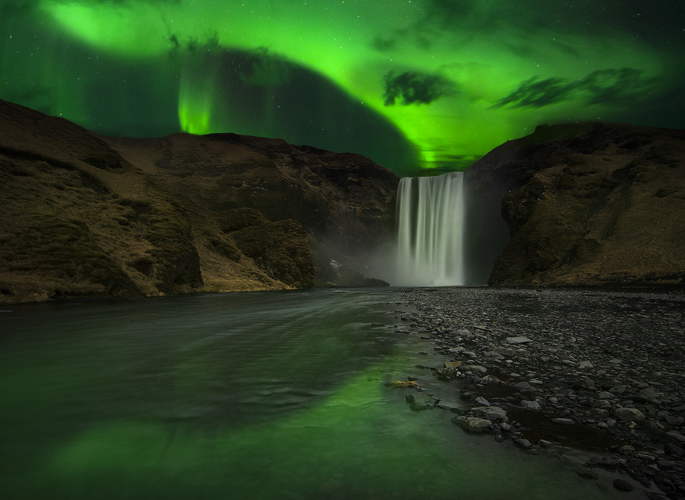 Skgafoss waterfall with Icelands Northern Lights during campervan road trip