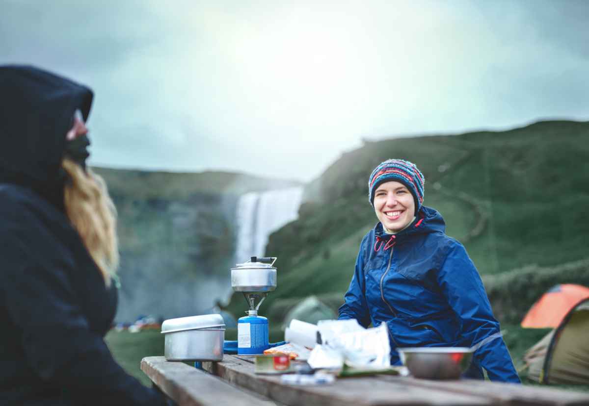 Two women cooking with their camping kitchen equipment