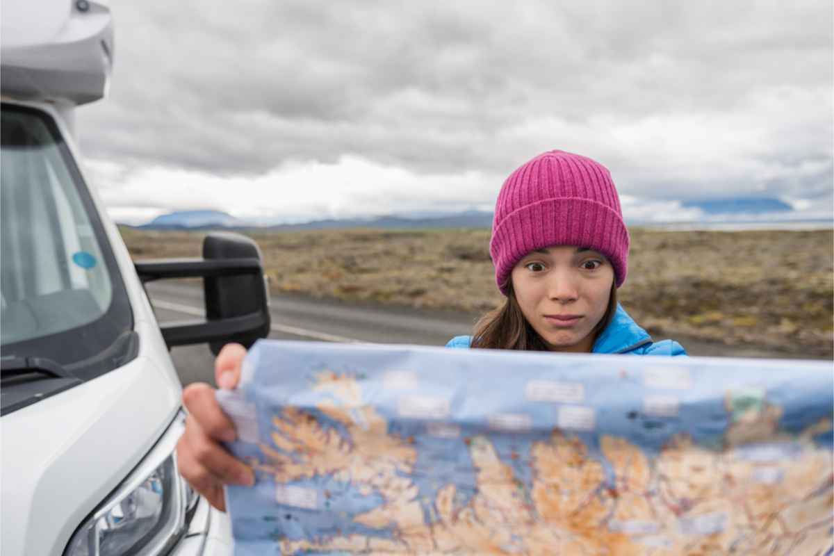 woman holding a map of Iceland trying to find the way