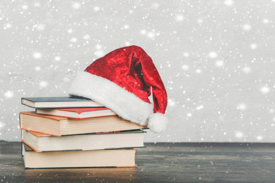 stack of book with a Santa's hat on top