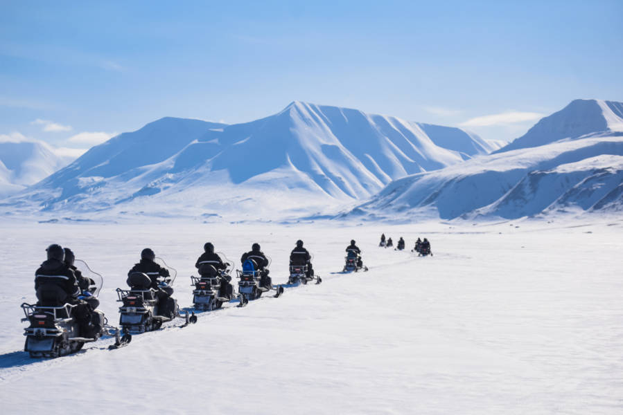 A group of tourists snowmobiling in Iceland