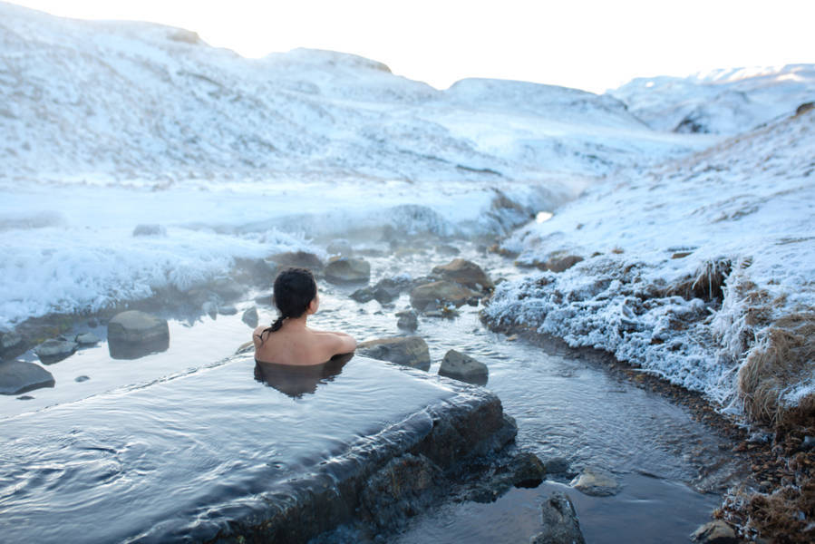 woman enjoying a hot spring in the low season of Iceland