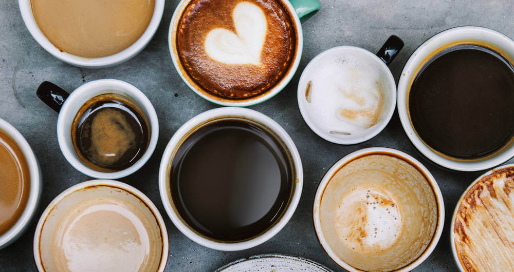 Several cups of coffee, cappuccino and espresso on a table