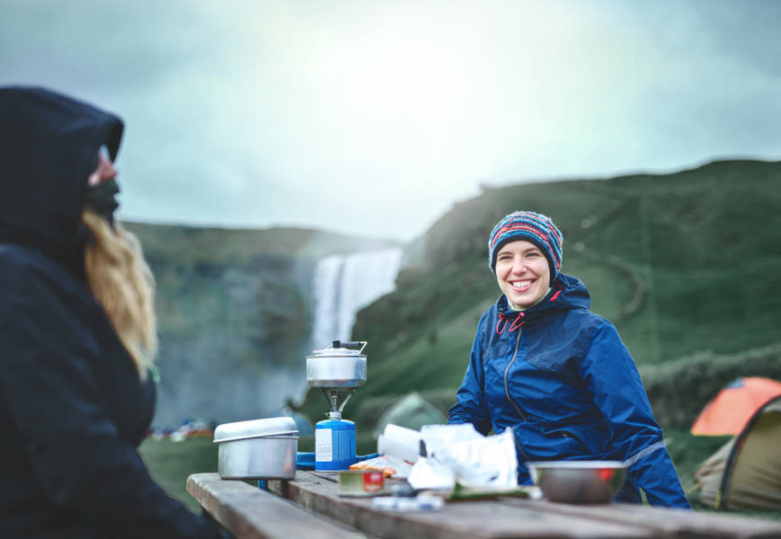 Tourists cooking in the outdoors by their camper
