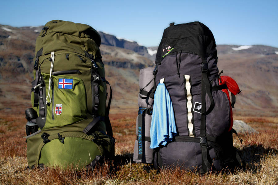 two camping backpacks on a table with an Iceland flag patch