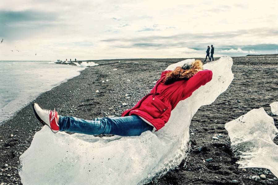 Tourist chilling out laying on an giant iceberg piece