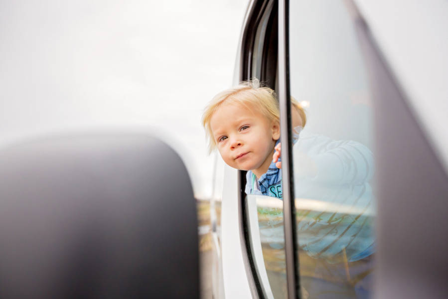 Toddler sticking his head out of his campervan window