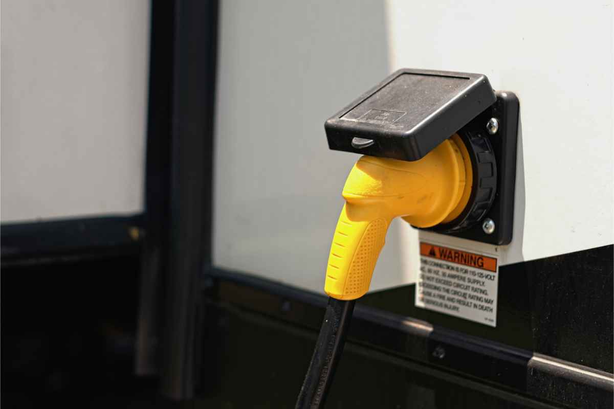 Rv plugged to a campsite electric pole