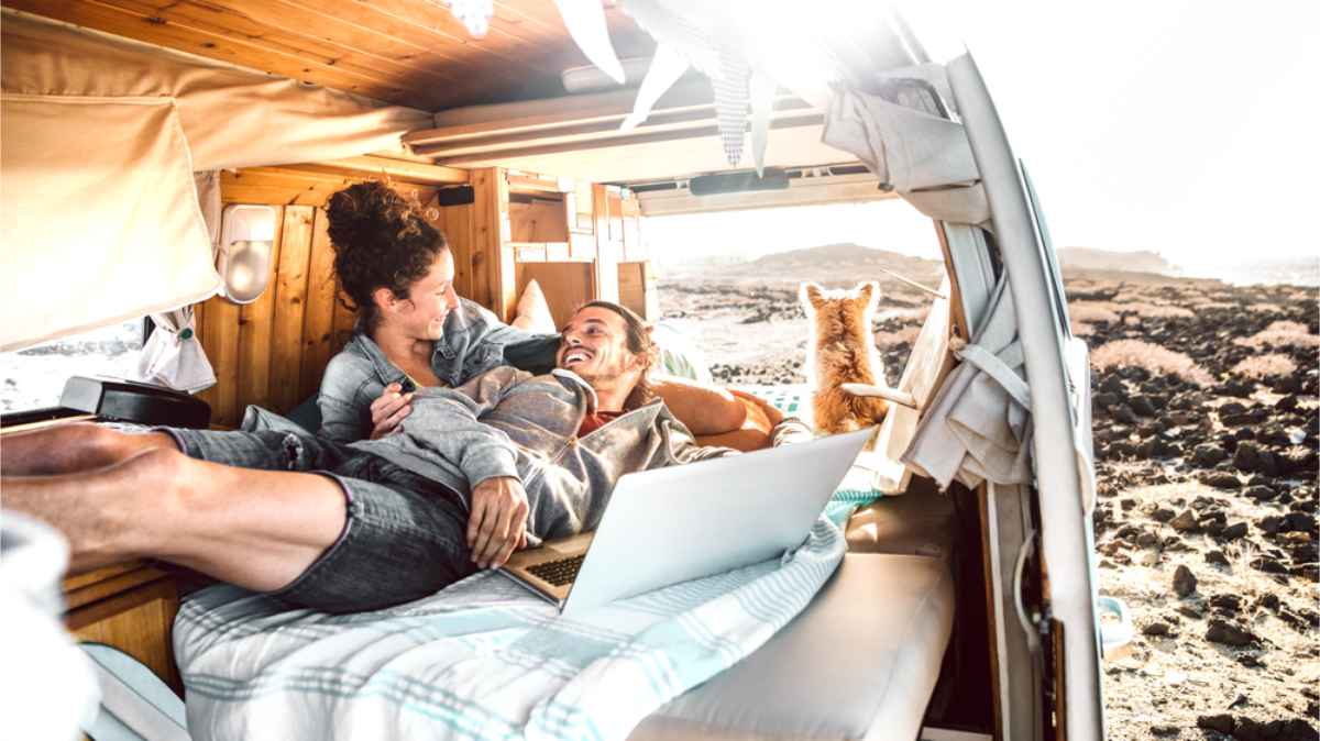 Couple working on their laptop inside of their campervan 