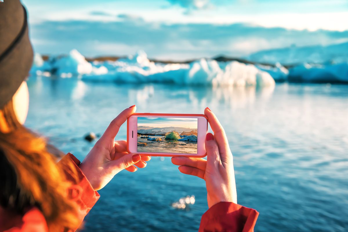 Man working remotely in Iceland sitting by a geothermal hot spring