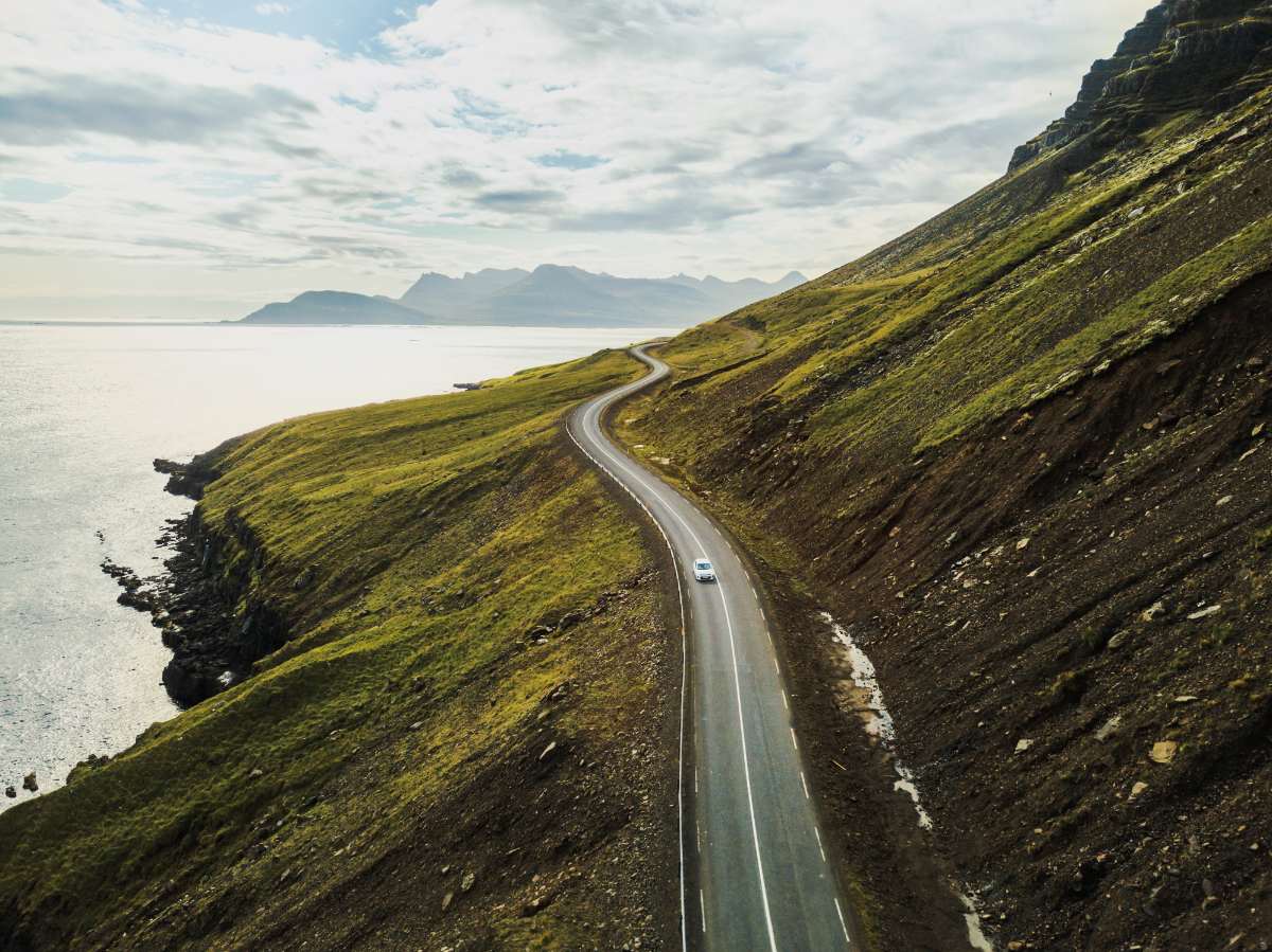 kid wheeling a carry-on bag on a road representing a road trip in Iceland with babys