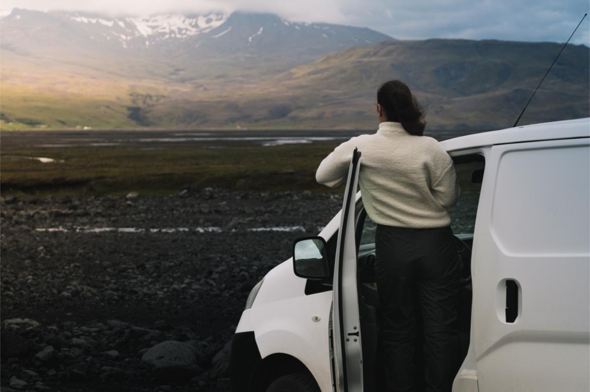 Young woman enjoying the impressive views of Iceland's landscapes from her camper