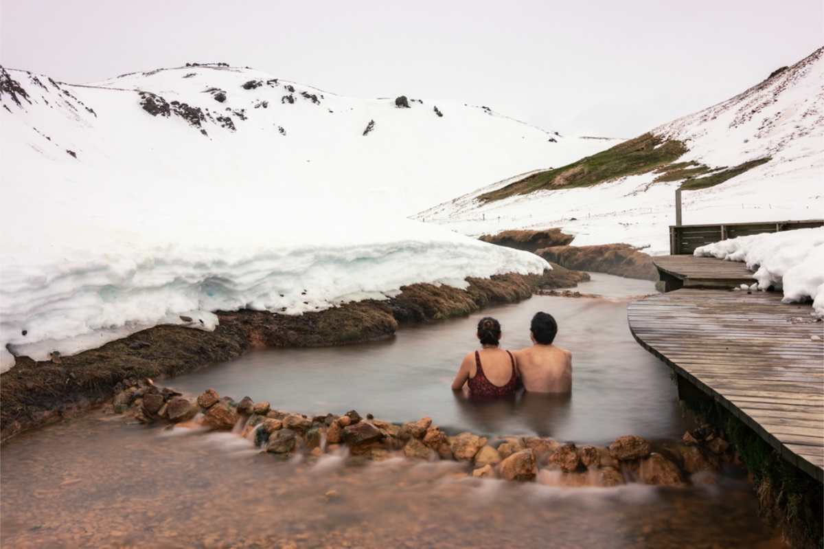 Two tourists enjoying the warm waters of Reykjadalur hot river