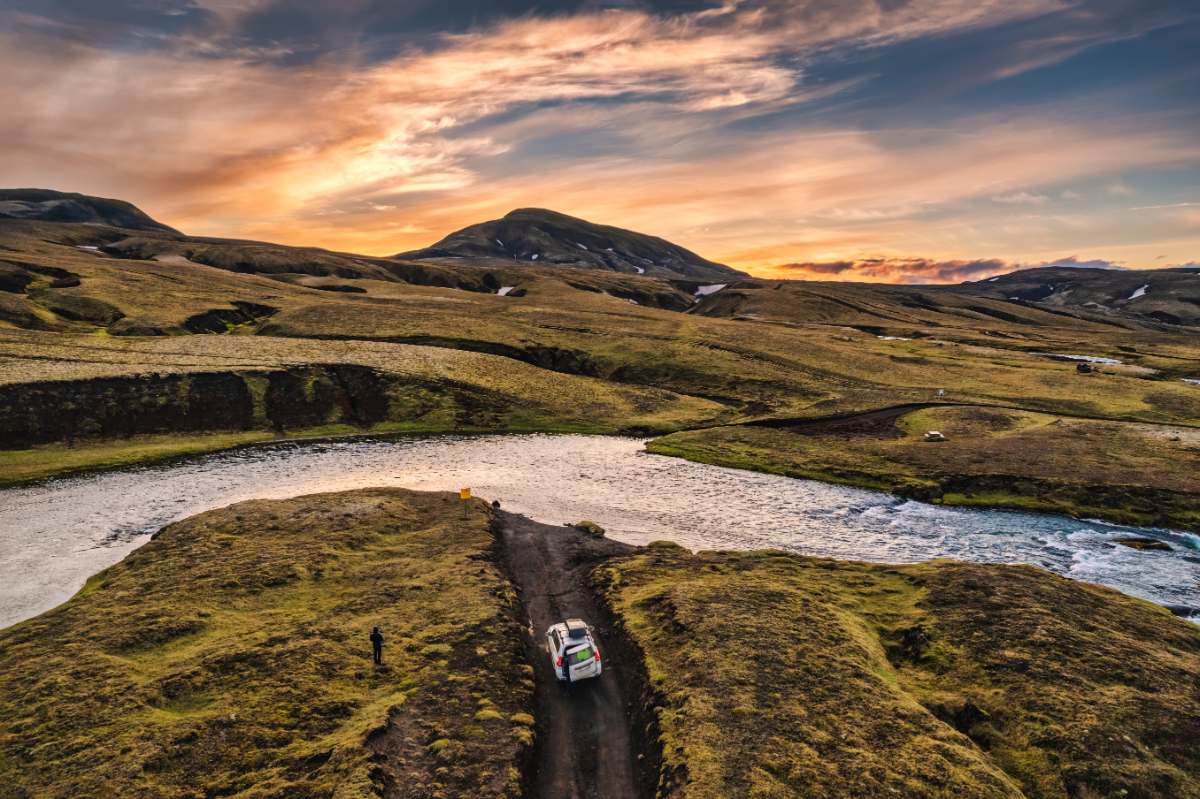 kid wheeling a carry-on bag on a road representing a road trip in Iceland with babys