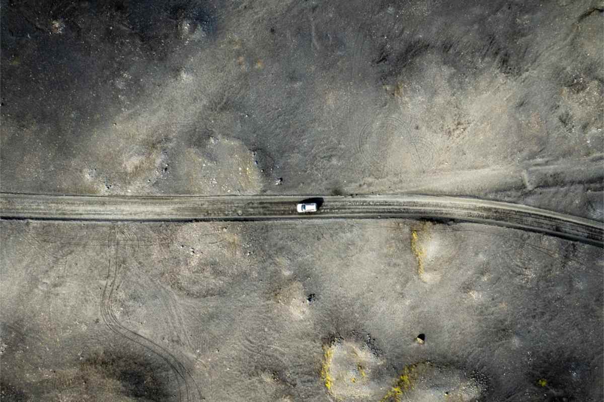 Top view of a camper rolling through an impressive volcanic area