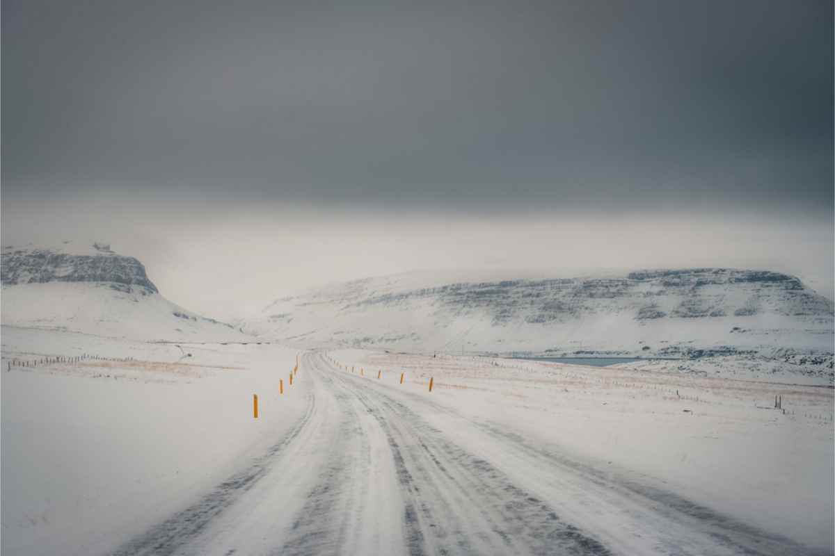 Bad road conditions with snow covering the road and the wind blowing sideways