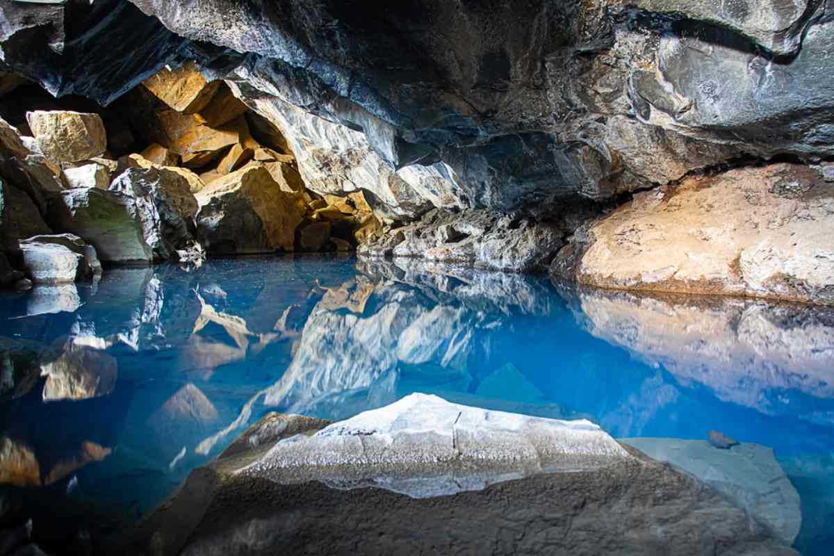 Man working remotely in Iceland sitting by a geothermal hot spring