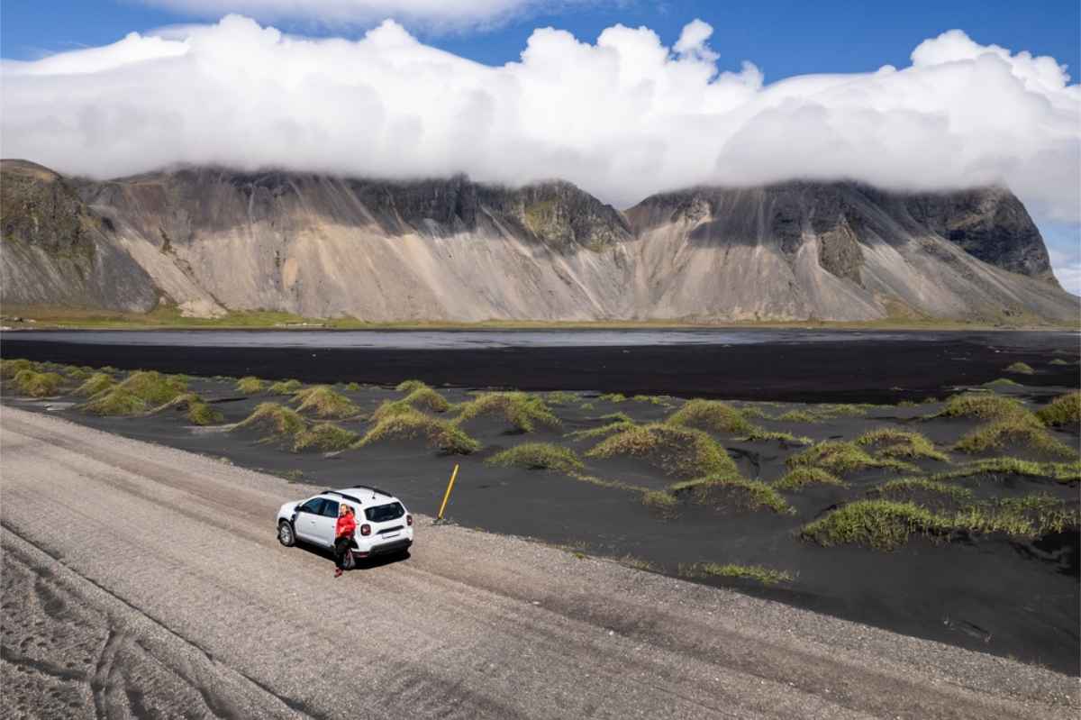 A white 4x4 car on the road to Vestrahorn