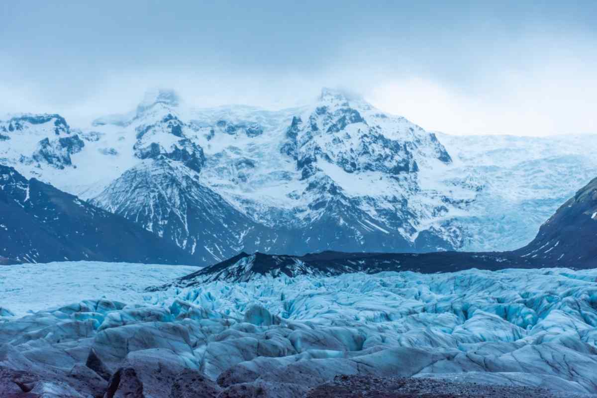 Huges of blue of the blocks of Ice of a glacier against a mountain range