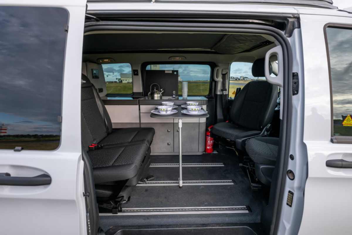Interior view of the Mercedes Marco Polo 4x4 camper with a dining table set up