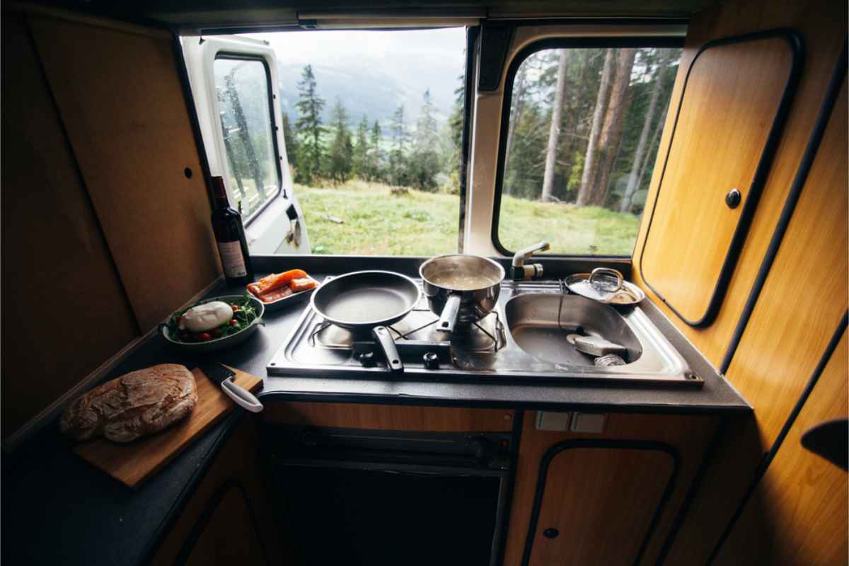Indoor in-built camper kitchen with beautiful views through a window