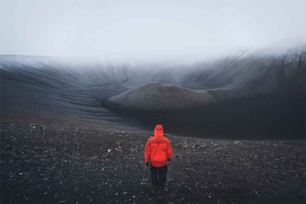 Tourist wearing a bright, waterproof jacket in a volcanic area of Iceland