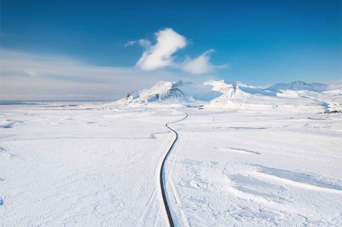 Winding road in Iceland with the landscape fully covered in snow