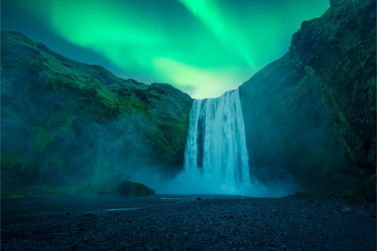 Skogafoss waterfall with the northern lights dancing above