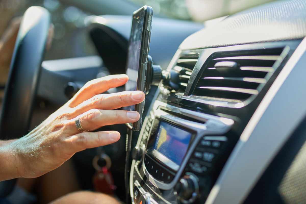 Driver checking wind conditions on a phone inside a vehicle before continuing a road trip in Iceland