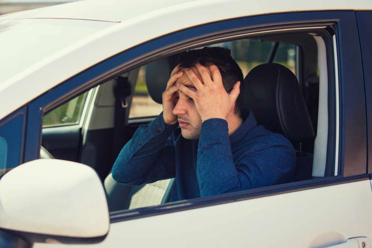 Stressed driver sitting inside a car after dealing with wind-related damage in Iceland