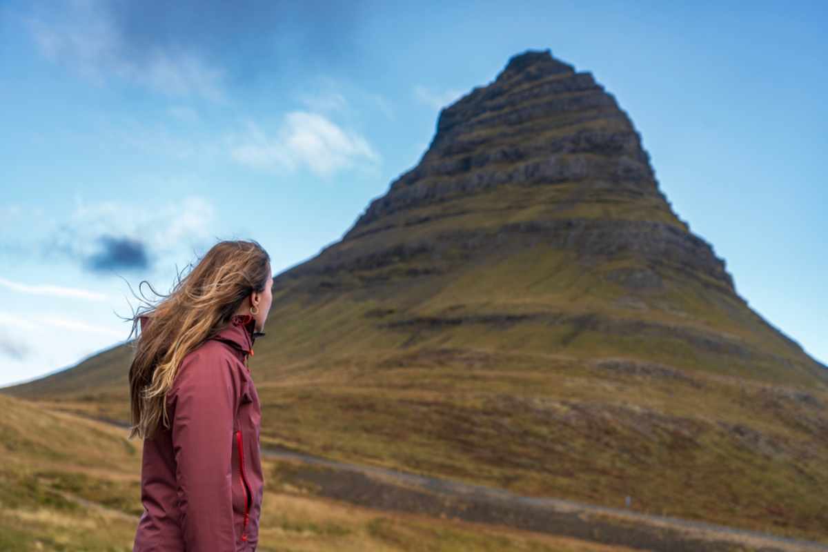 Traveler near Kirkjufell in Snæfellsnes, Iceland, a region known for scenic roads and sudden strong winds