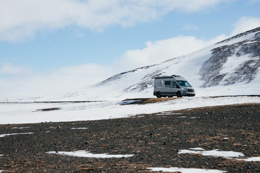 Campervan parked in the middle of a wintry landscape 