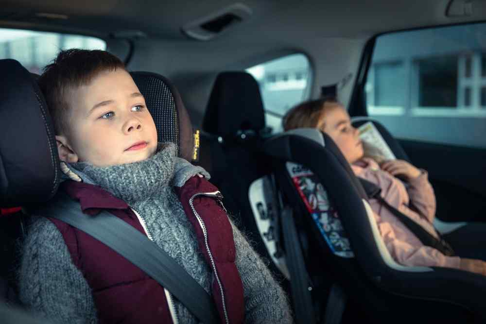 Car seats mandatory in Iceland Children sitting in car seats and wearing seat belts in the back of a vehicle.