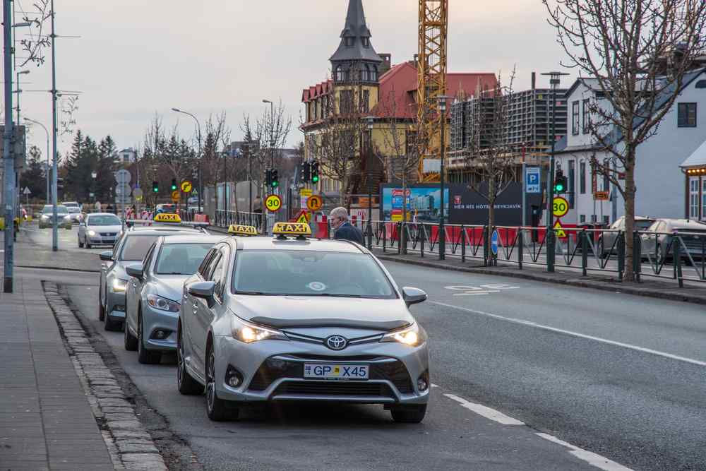 Taxis in Iceland Taxis driving through a city street in Reykjavík.