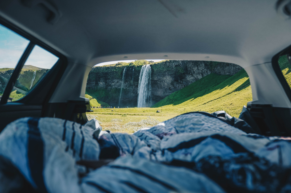Views of a waterfall from a cheap camper van in Iceland