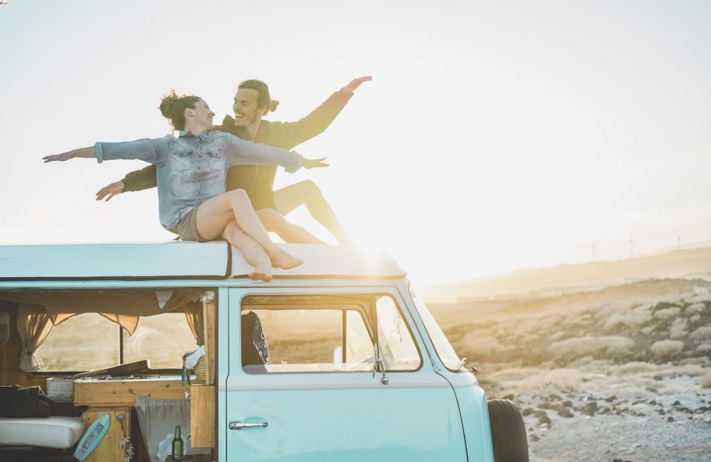 couple sitting on top of their camper